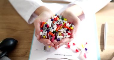 Pharmacist doctor hands holding lot of multicolored medical capsules closeup 4k movie slow motion. Regular intake of medicines concept 