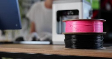 Spools with multicolored plastic for 3D printer on desktop closeup 4k movie slow motion. Materials for 3d design concept 