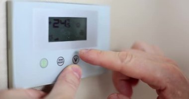 Male hand adjusting temperature on air conditioner closeup 4k movie slow motion. Comfortable temperature at home concept 