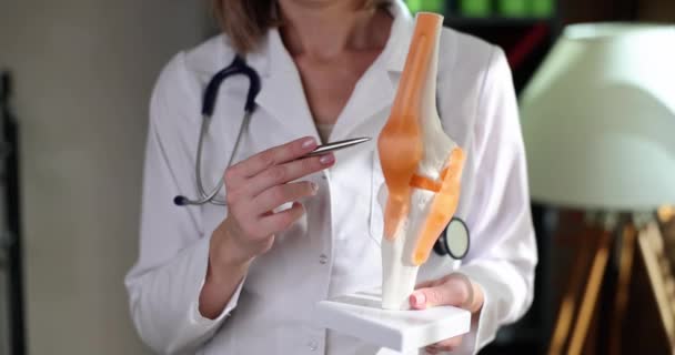 人間のクローズアップ4K映画スローモーションの人工膝関節にペンで示す医師 関節損傷診断と治療の概念 — ストック動画
