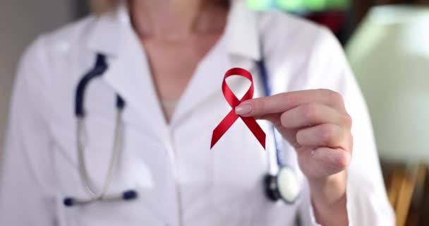 医者はHivとの闘いの赤いリボンのシンボルを保持4K映画スローモーションを閉じます Hiv予防エイズの概念 — ストック動画