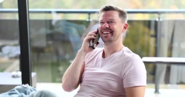 Happy joyful man is talking on the phone with girlfriend or business partner. Emotions of successful guy speaks on smartphone