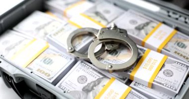 Open suitcase with stack of million dollars and handcuffs. Bribe arrest and detention of a diplomat