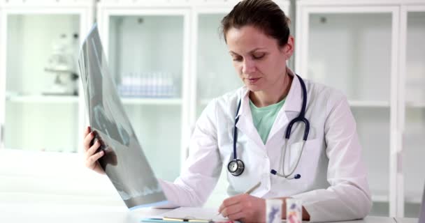 Doctor Traumatologist Holds Ray Human Spine Writes Medical Diagnosis Examination — Stockvideo