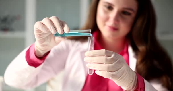 科学者は実験室の試験管に青い液体を注ぐ 毒性液体の研究 — ストック動画