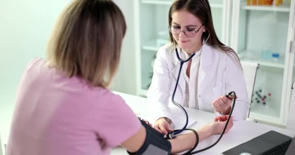 Doctor Using Sphygmomanometer Stethoscope Checks Blood Pressure Woman Clinic Signs — Video Stock