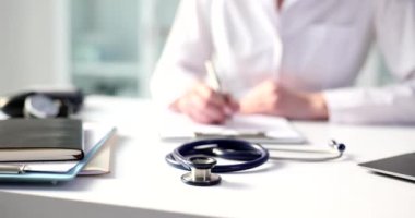 Doktor terapistin kardiyoloğu tıbbi belgelere notlar yazar. Sorunu ve şikayeti olan hastaya tıbbi muayene ve tedavi için reçete verilir