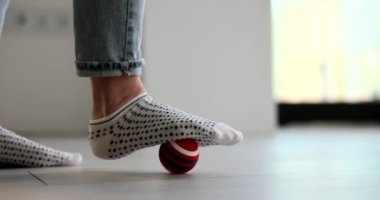Kadın bacak masajı yapıyor. Topa yakın çekimde 4K film yavaş çekimde. Düztaban kavramının tedavisi ve önlenmesi için ev çalışmaları