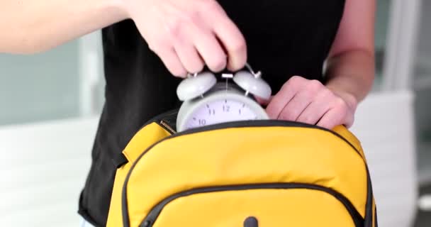 Woman Takes Out Alarm Clock Yellow Backpack Time Planning Trip — Vídeo de Stock