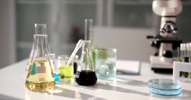 研究室での研究のための黄色透明液体と黒原油とフラスコ 化学実験 実験概念 — ストック動画