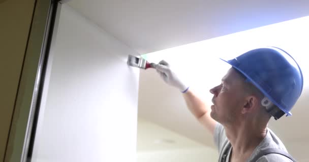Männliche Bauarbeiter Malen Wand Weiß Mit Pinsel Film Zeitlupe Abschlussarbeiten — Stockvideo