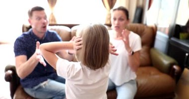 Father and mother scolds daughter closes her ears with hands. Family problems frightened unhappy child