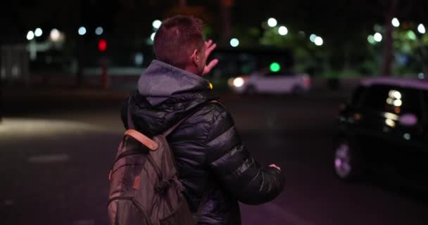 Man Stands City Street Evening Hails Taxi Waves Friend Tourist — Stock video