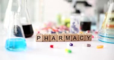 Pharmacy text different pills and liquids in flasks in laboratory closeup. Chemical analysis of drugs