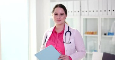 Gülümseyen profesyonel kadın doktor, elini tutan terapist. Tıbbi klinikte ya da hastanede el sıkışma hareketi.