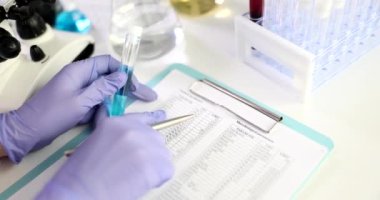 Mavi sıvı ve kimyasal bileşim veri tablosuna yakın deney tüplü bilim adamı doktor. Zehirli ve zehirli sıvıların incelenmesi
