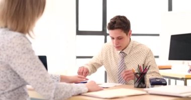 Manager gives contract to specialist for signing in office. Student employment and internship concept