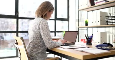 Business consultant or manager works in office at laptop. Modern stylish office and workplace