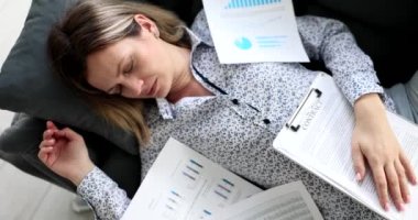 Yorgun ve yorgun bir iş kadını ofis odasındaki kanepede uyuyor. Analiz ve aşırı çalışma iş analizinde sorunlar