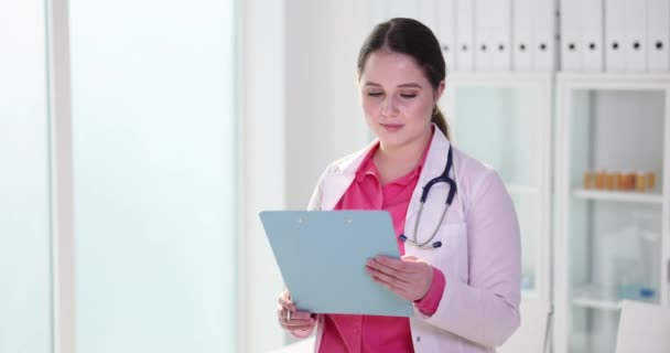 Vrouwelijke Gynaecoloog Onderzoekt Medische Documenten Glimlacht Ziektekostenverzekering Medische Bijstand — Stockvideo