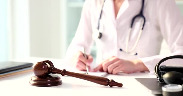Wooden Gavel Judge Table Medical Clinic Doctor Filling Out Paperwork — Vídeo de stock