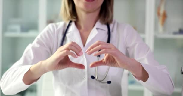 心臓病のセラピストは心臓のジェスチャーの閉鎖を示しています 医療支援 健康保険の象徴 — ストック動画