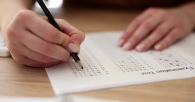 Student take exam with hands and write the exam test with pencil. Standardized test with answers