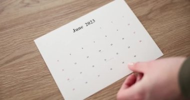 Person puts calendar of different months 2023 on table. Motivation goal planning and agenda