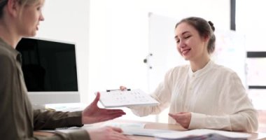 Women business partners discussing documents with charts in office 4k movie slow motion. Teamwork for successful business concept