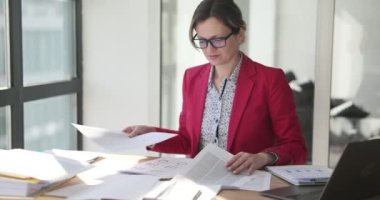Female marketing manager working with financial and marketing documents in office. Businesswoman seo engaged in paperwork and analytics