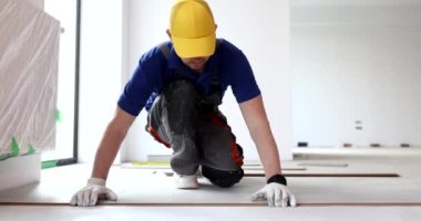Worker laying vinyl or laminate flooring renovating home or office. Laminate laying rules and instructions