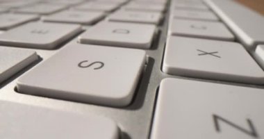 Masanın üzerinde beyaz modern yakın çekim bilgisayar klavyesi var. Programcının klavyesini ve uzak çalışmasını sipariş et