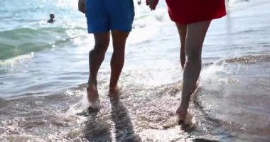 Married couple walks along sea along beach. Honeymoon and holiday enjoyment