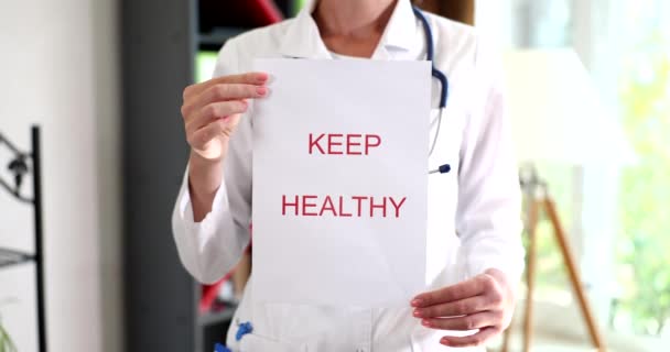 Woman Doctor Therapist Holds Paper Words Keep Healthy Healthy Lifestyle — Vídeo de Stock