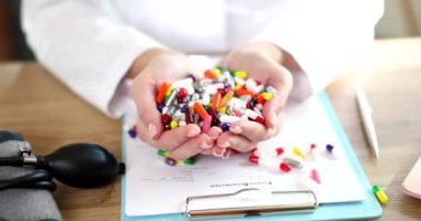 Doctors hand holds many different pills in clinic. Criteria for medical choice of medicines