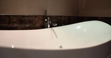 White bathtub and jacuzzi decorate interior of bathroom. Choosing whirlpool bath and tips