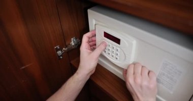 Steel safe in closet in hotel room. Entering password into safe in hotel room