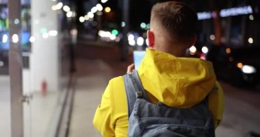 Man with backpack walks down street with mobile phone in hands searching for route. City navigation and travel