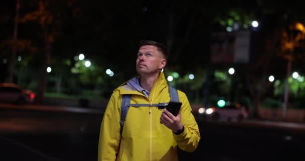 夕方になるとスマートフォンを持った男性観光客が市内で迷子になった 知らない街で迷子になったブロガー — ストック動画