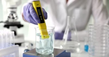 Stirring liquid in beaker with magnetic stirrer and tester. Scientist investigates toxic substances in water