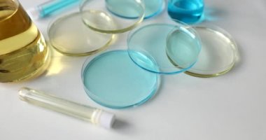 Various glassware and test tubes with light blue liquid and oil in laboratory. Toxic poisonous liquid substances in lab