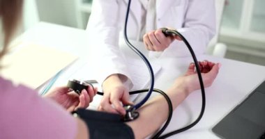 Doctor measures blood pressure of patient with health problem in clinic closeup. Diagnosis and treatment of arterial hypertension concept