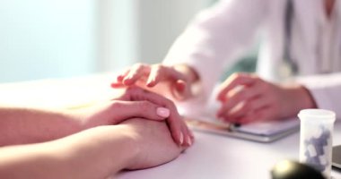 Hands of female doctor hold patient hand for encouragement and sympathy. Bad medical news and support