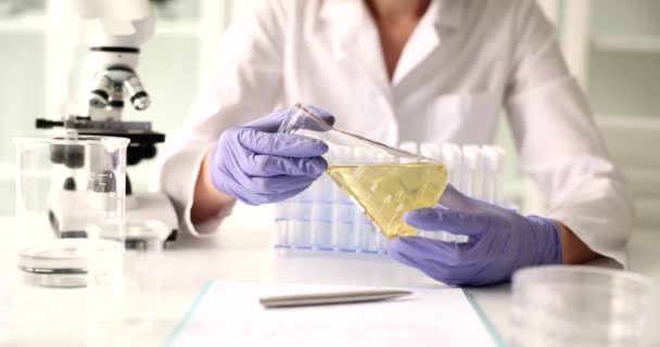化学者は黄色油液と生物学的研究で試験管を保持しています 自動車および産業用オイルの技術コンセプト — ストック動画