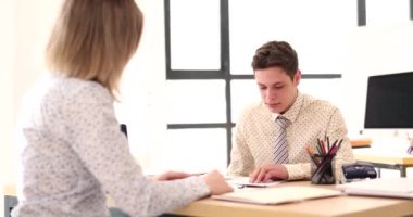 Dealer visits client at desk in office. Intern signs an employment contract for internship in company