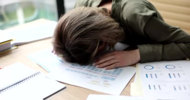 İş çizelgeleri ve mali raporlar üzerinde uyuyan yorgun bir kadın. Fazla mesai yorgunluğu depresyon ve staj