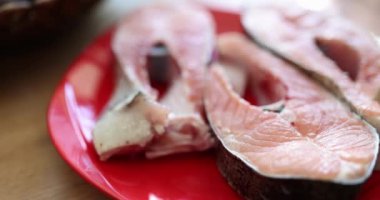 Raw juicy tasty pieces of red salmon on plate closeup. Salmon composition calorie content and benefits for body