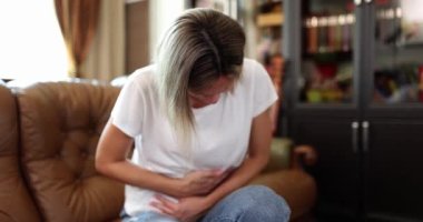 Beautiful woman with severe abdominal pain at home. Painful menstruation or pregnancy