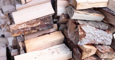 Many of chopped pine wood for firewood neatly stacked closeup. Harvesting firewood for winter or for bath