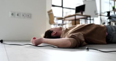 Electrocuted electrician lies unconscious on floor. Woman in office was electrocuted